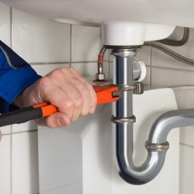 Close-up Of Male Plumber Repairing Sink In Bathroom